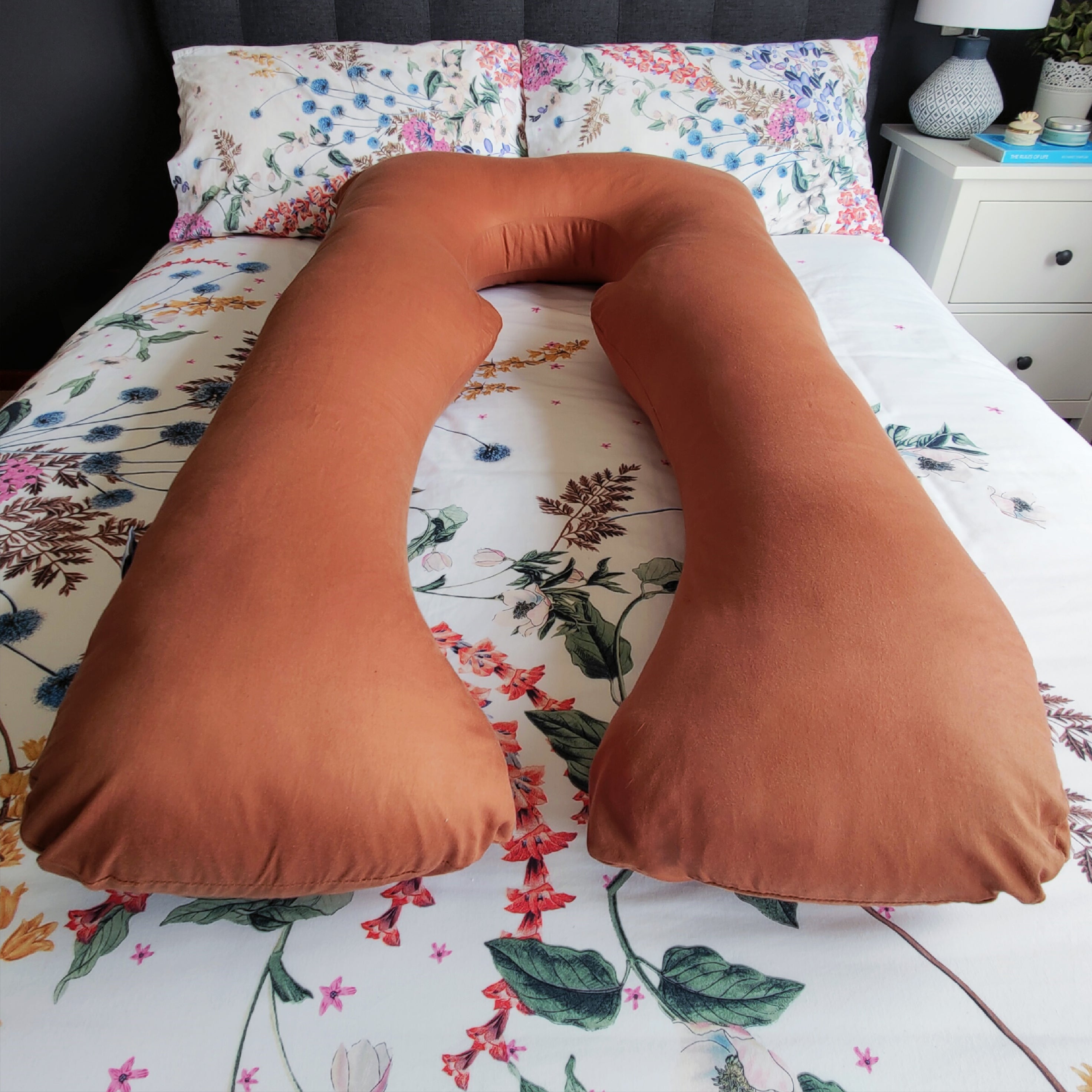 Chocolate Pillow Pod Full Body Support Pillow on Bed, with Flowery Bed Spread